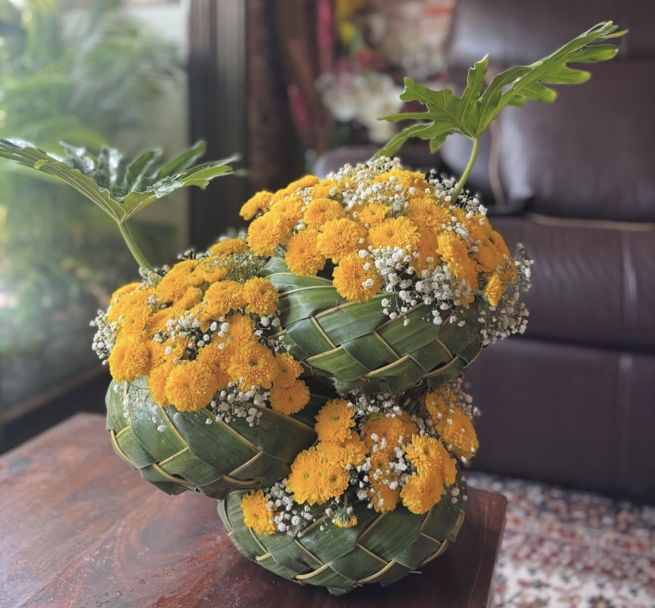 Tiered woven leaf baskets with golden marigolds and baby's breath